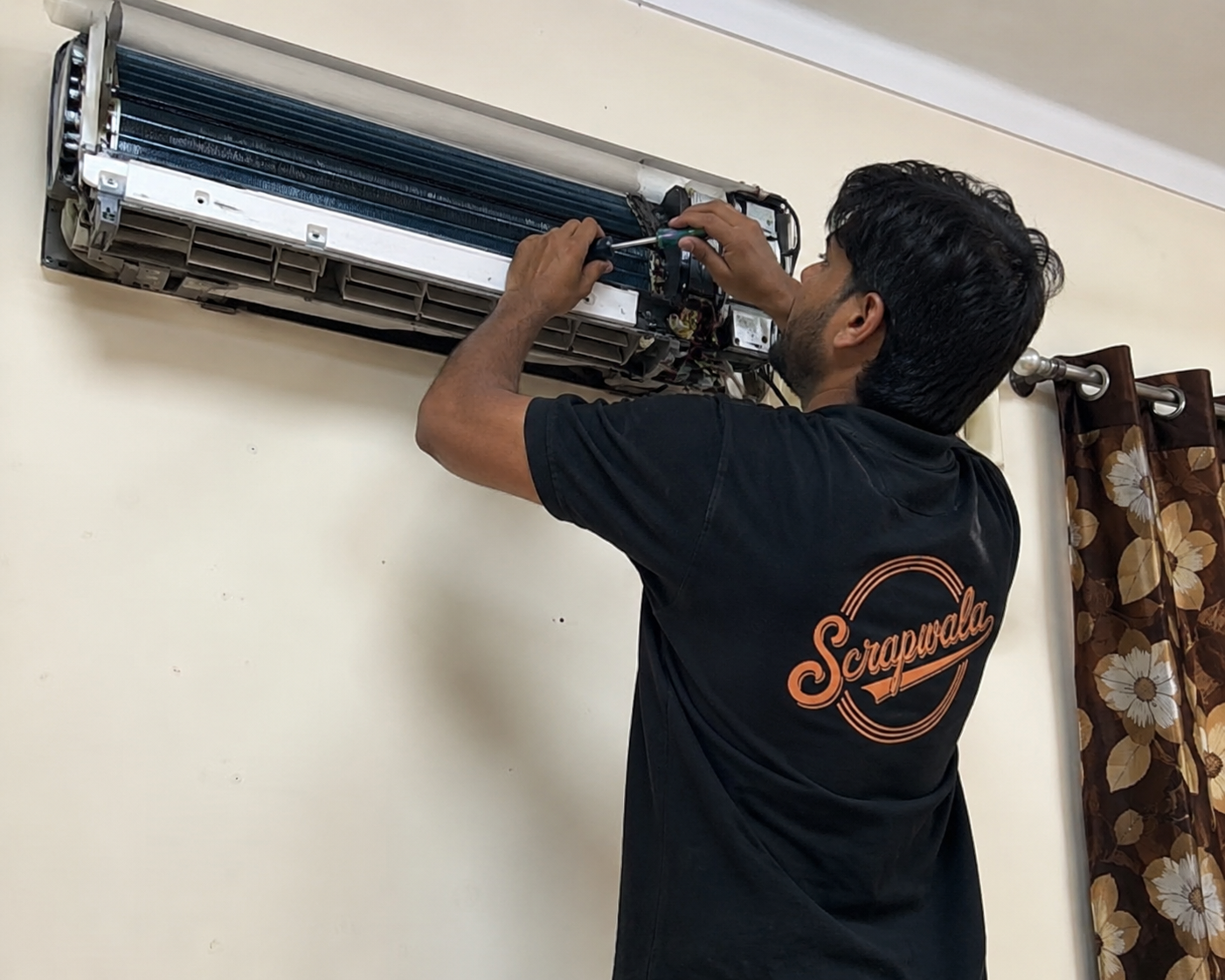 Technician dismantling split AC unit